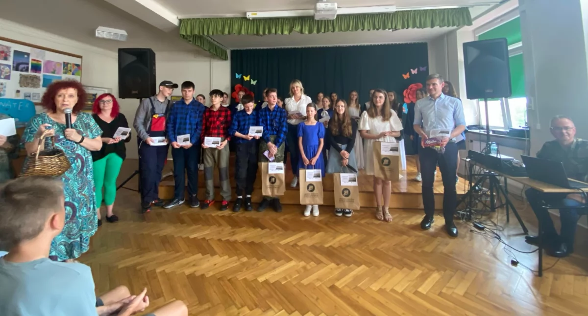 Zdjęcie występujących uczniów z gospodarzami i prelegentem
