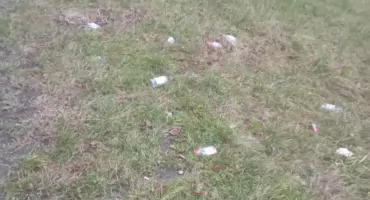 Osiedlowe libacje alkoholowe i butelki na trawniku 